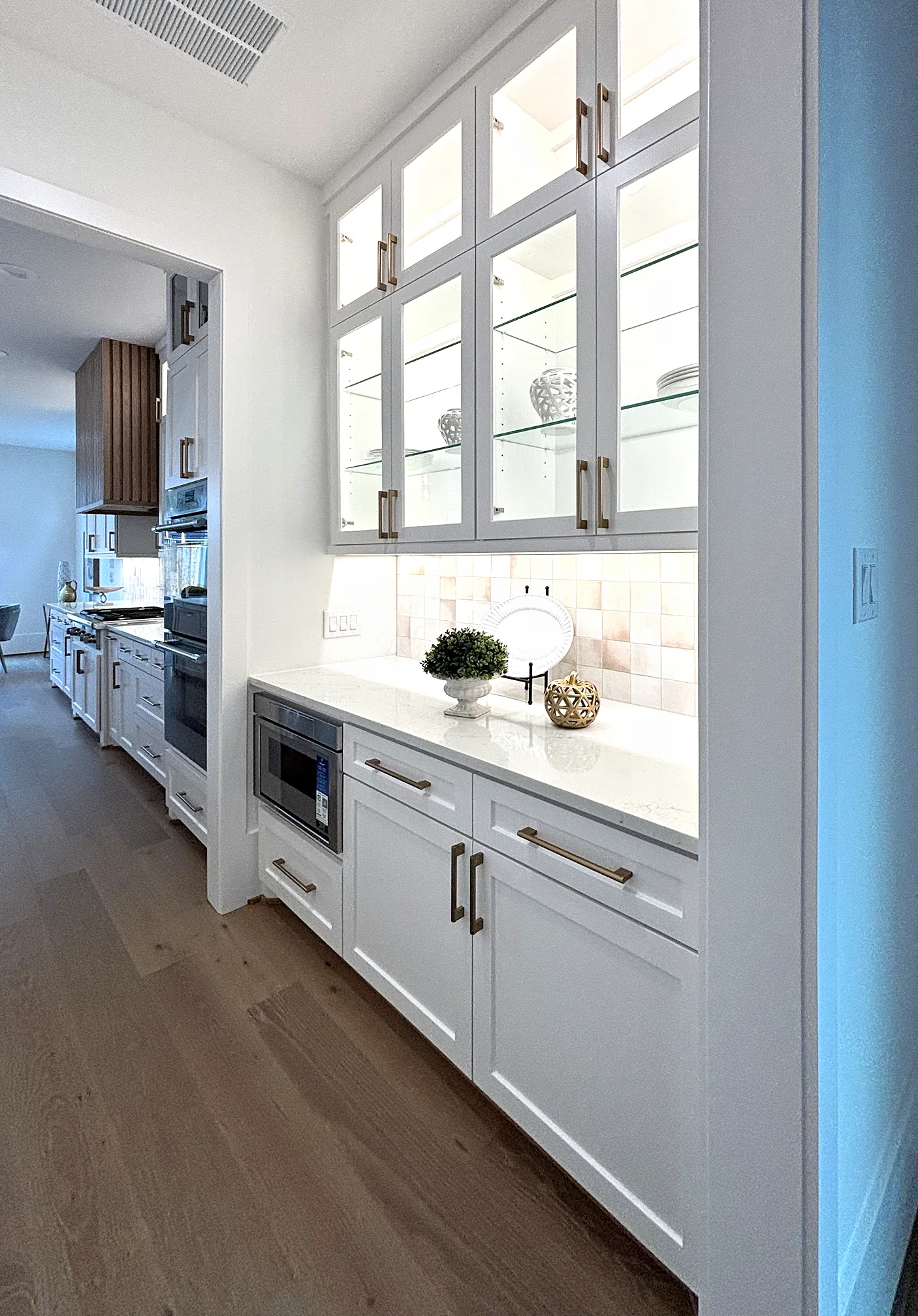 Butler's pantry with glass-front cabinets and undercabinet lighting
