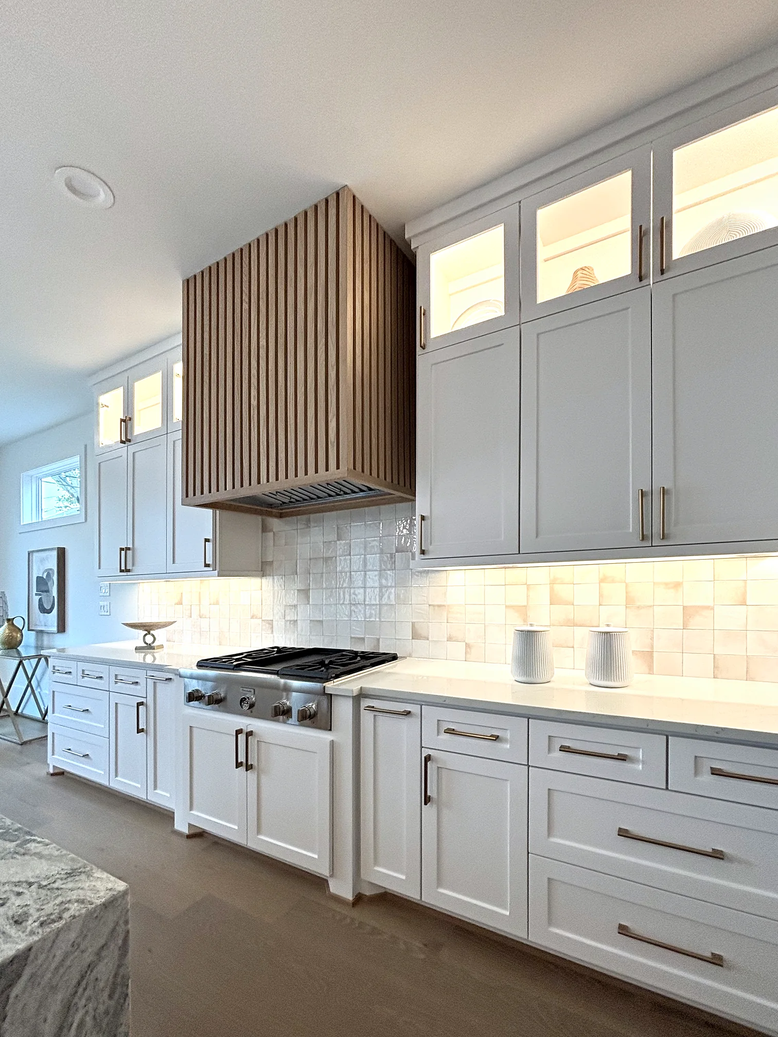 Kitchen range wall with brass sconces flanking a plaster hood