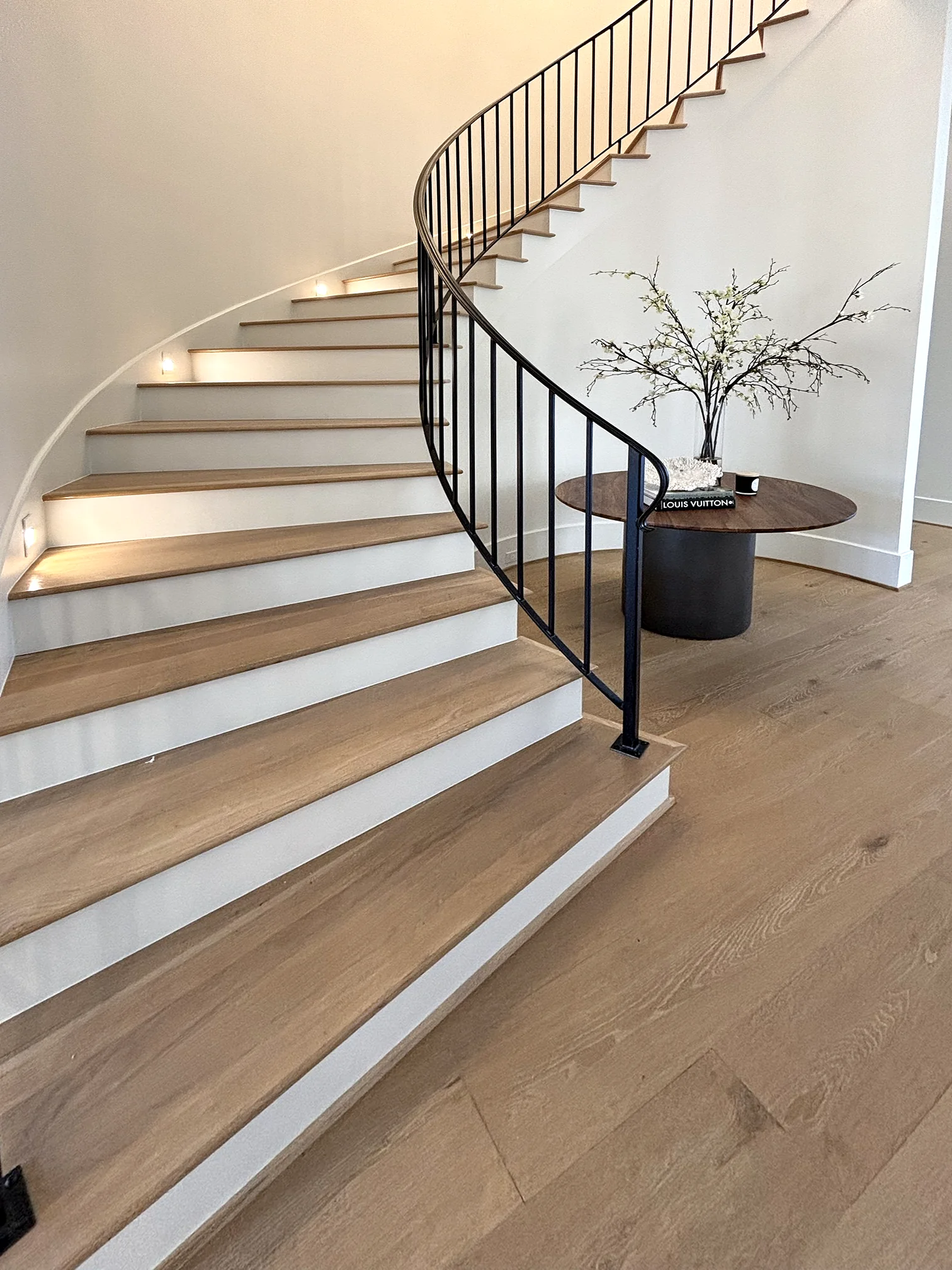 Curved staircase with a cascading chandelier
