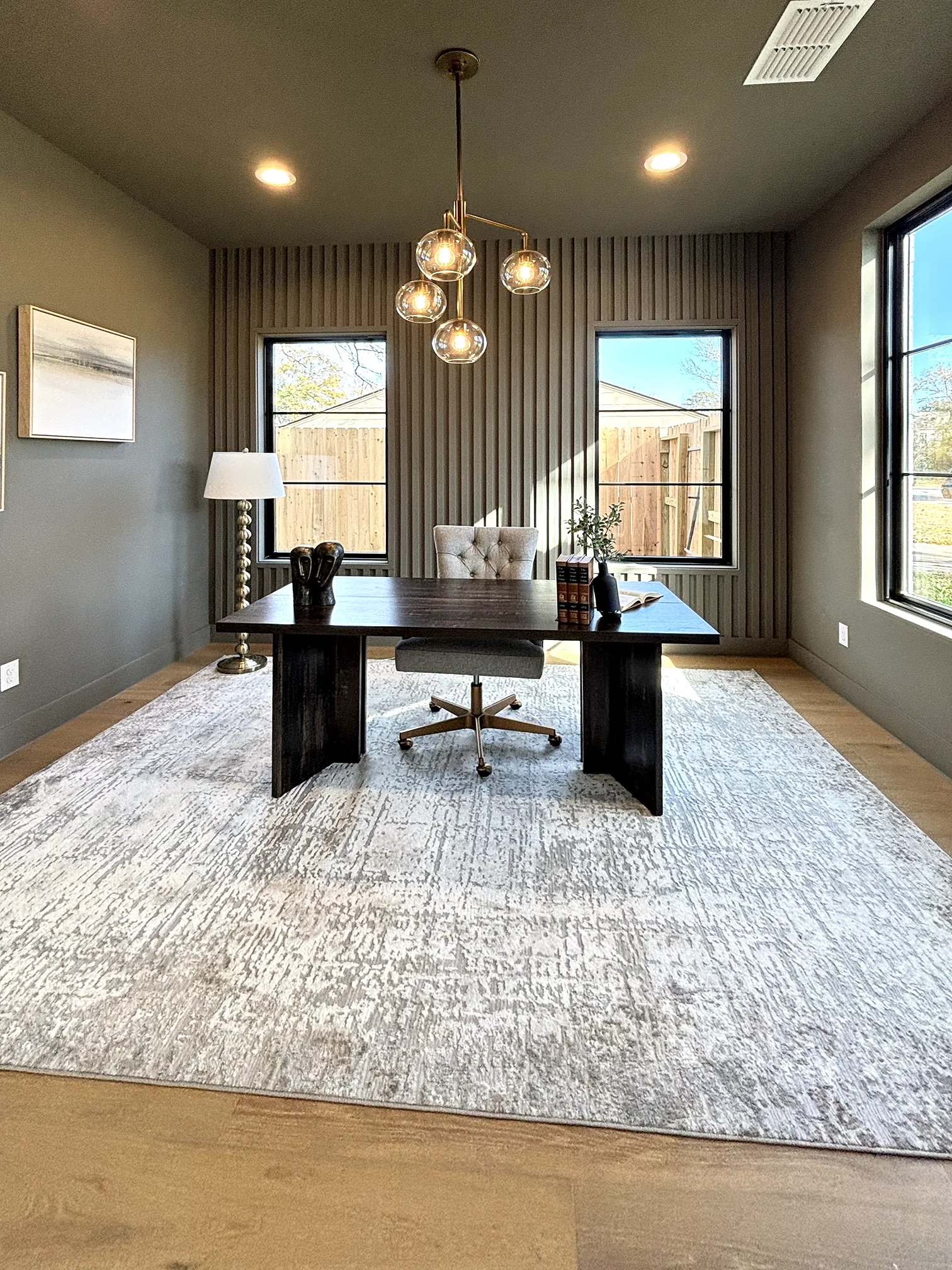 Home office with brass globe chandelier and slatted accent wall