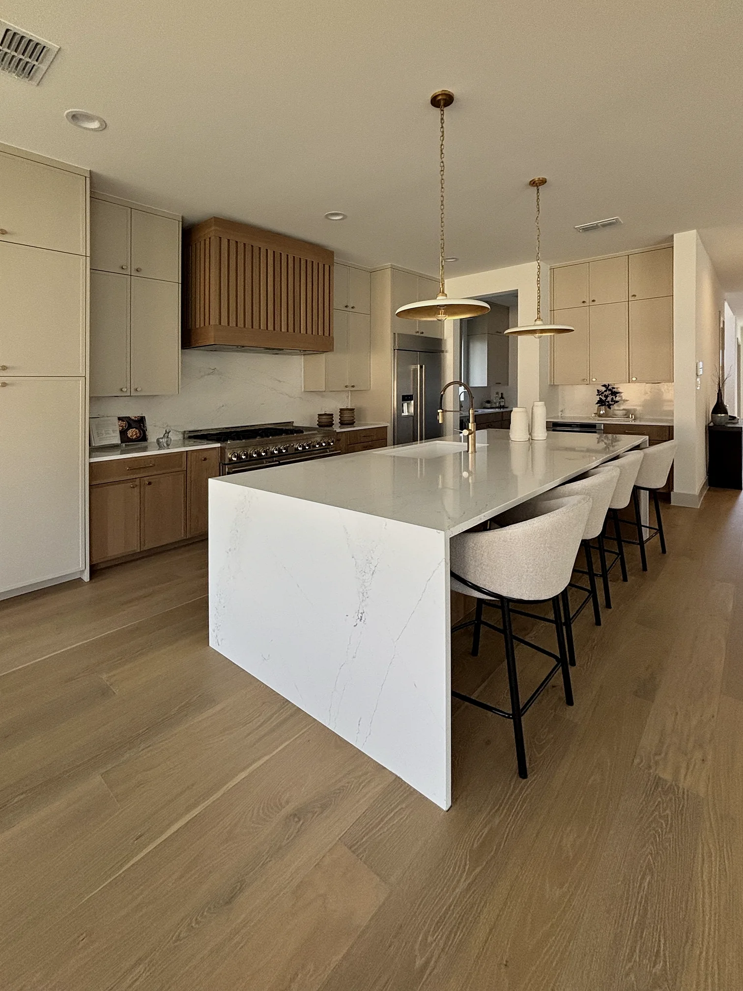 Kitchen with a white island and brass pendant lighting